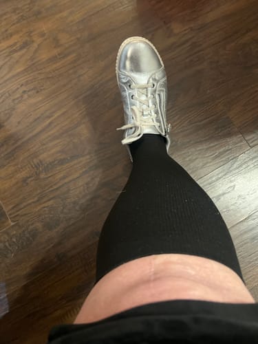 Customer wearing the black, knee-high Everstride Compression Socks with a silver shoe.
